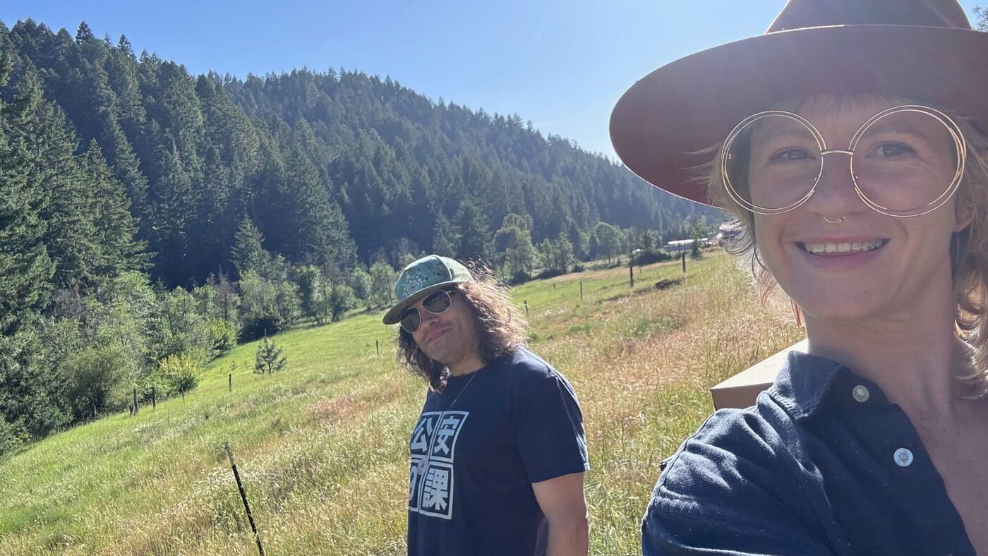 Sasha and Alec outdoors in a forested Southern Oregon meadow.
